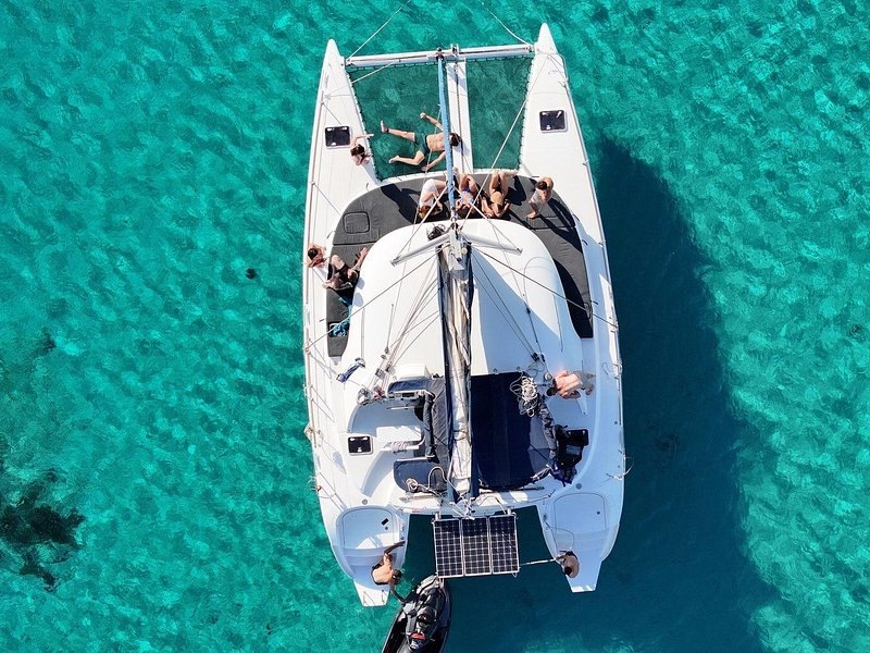 A catamaran anchored over clear turquoise water in the Aegean