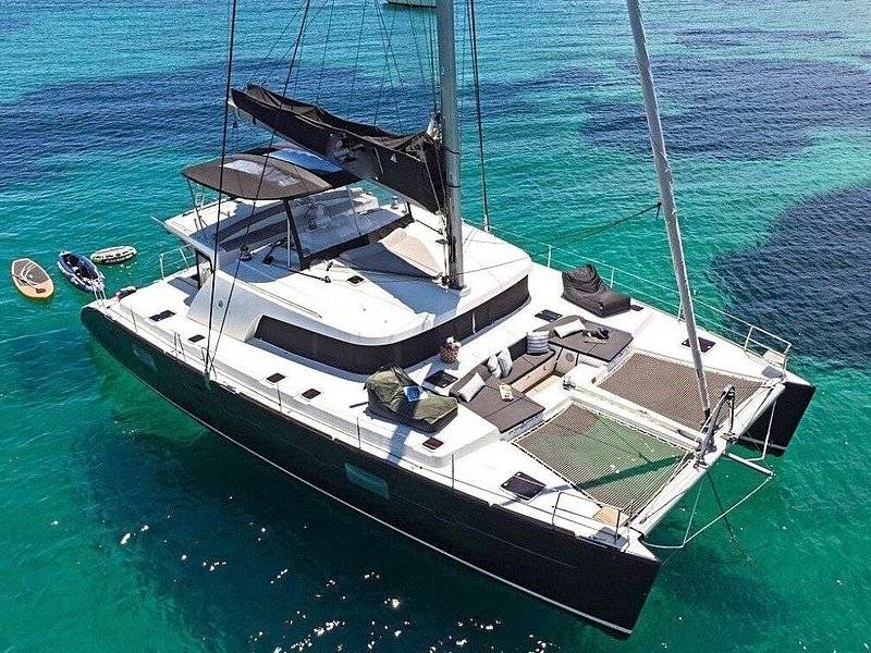 A catamaran seen from above, cutting across bright turquoise water