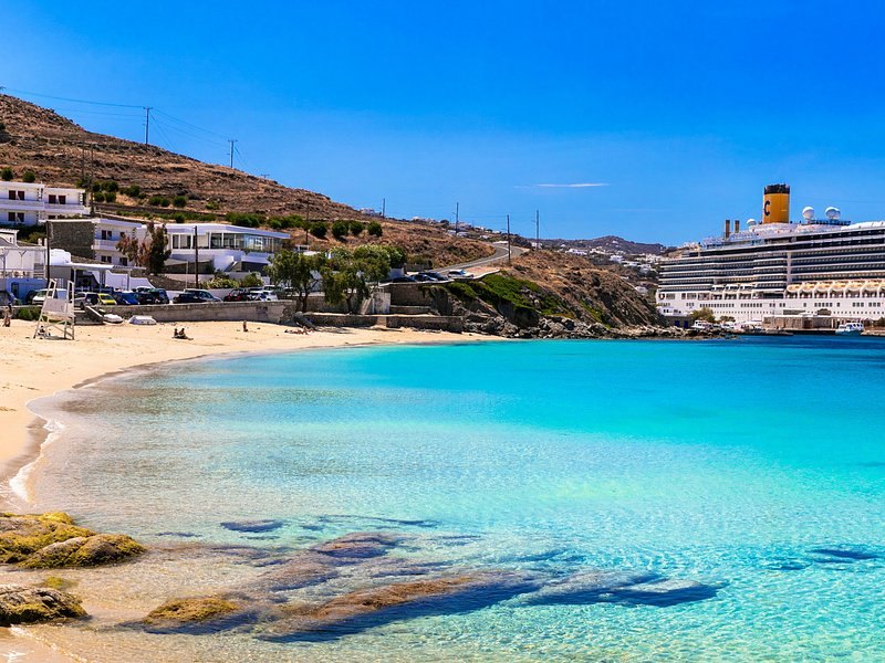 A crescent of pale sand and turquoise shallows on the Mykonos coast