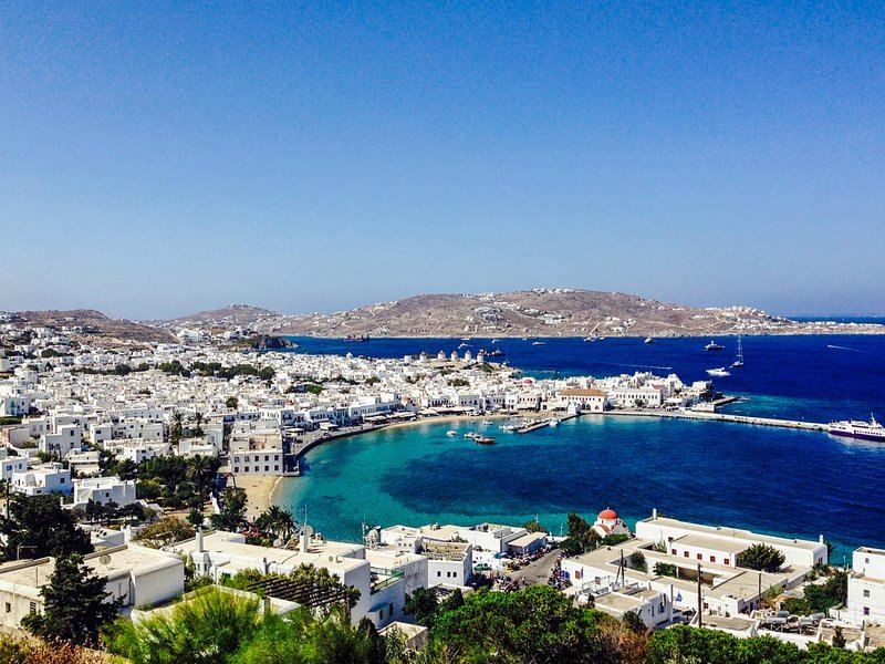 Mykonos Town and the bay from the hill above, with the sun going down